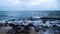 Sea waves break on the rocky stones on the beach. Seascape, storm view from the shore. Cloudy day. HD video