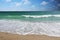 Sea waves break on a sandy beach as background