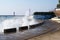 Sea waves breaking on the pier, resort embankment, sun glare on the water.