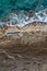 Sea waves breaking on rocky shore, aerial vertical shot