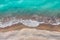 Sea waves breaking on a sand shore, top view directly above