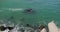 Sea waves crash against rocks and concrete breakwaters