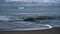 Sea waves crash beach on dark stormy weather ocean coast landscape background.