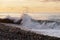 sea waves crashing on a pebbly shore On the Sunset