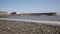 Sea and waves lapping on pebbles Minehead harbour Somerset England with boats in summer