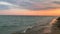Sea waves on pink sunset, cloudy sky, aquamarine