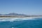 Sea, waves, sandy beach and mountains behind