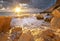 Sea waves during storm on sunset splash on stones