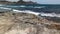 Sea waves touching the rocky coastline, close-up