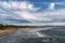 Sea waves wash seacoast under cloudy sky in Oregon, USA. Cannon beach Oregon