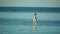 Sea woman sup. Silhouette of happy middle aged woman standing, surfing on SUP board, confident paddling through water