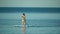 Sea woman sup. Silhouette of happy middle aged woman standing, surfing on SUP board, confident paddling through water