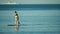 Sea woman sup. Silhouette of happy middle aged woman standing, surfing on SUP board, confident paddling through water