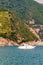 Sea yacht near the rocky coastline with vineyard, olive leveled terraces on green mountains in Monterosso Al Mare, Cinque Terre,