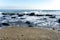 Sea â€‹â€‹landscape with sea waves falling on the rocks scattered along the seashore