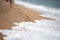 sea â€‹â€‹waves wash footprints in the sand