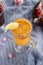 Seabuckthorn tea in a glass cup on blue table