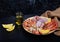 Seacuterie board with raw shrimps, squid, shellfish, langoustines and vegetables on dark background