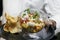 seafood ceviche or tartare in a glass bowl with crackers in close up