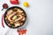 Seafood and chicken paella with rice, mussles, shrimps,chicken, tomatoes and wine in pan on white textured background, flat lay