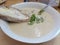 Seafood chowder with soda bread served in a white bowl Irish meal