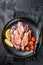 Seafood diner with grilled squid, calamary in a plate. Black background. Top view