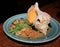 Seafood dish with conch shell in a plate, side view