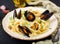 Seafood fettuccine pasta with mussels over black background.