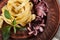 Seafood Fettuccine pasta with octopus, garnished with basil on a clay plate and fabric background