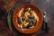 Seafood Mafaldine pasta with mussels and tomato sauce in a rustic plate. Dark background. Top view