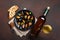 Seafood mussels and basil leaves in a black plate with wine bottle, wineglass, bread slices, fork, knife, burlap on rusty