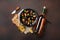 Seafood mussels and basil leaves in a black plate with wine bottle, wineglass, corkscrew, bread slices, burlap on rusty background