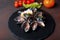Seafood mussels in cream sauce with lemon and basil on a stone and rusty background