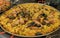 Seafood paella cooked in a large pan wok, street food festival