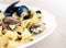 Seafood pasta spaghetti linguine wish mussels, clams, tomato sauce, fresh parmesan on the white plate in restaurant in Catania,
