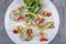 Seafood platter with deep fried squid rings, shrimp decorated with lemon on fresh arugula. Mediterranean appetizers. Top view