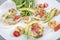 Seafood platter with deep fried squid rings, shrimp decorated with lemon on fresh arugula. Mediterranean appetizers. Top view