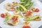 Seafood platter with deep fried squid rings, shrimp decorated with lemon on fresh arugula. Mediterranean appetizers. Top view