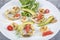 Seafood platter with deep fried squid rings, shrimp decorated with lemon on fresh arugula. Mediterranean appetizers. Top view