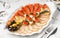 Seafood platter with salmon slice, pangasius fish, red caviar, shrimp, decorated with olives and lemon on marble background