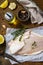 Seafood, raw white fish fillet for cooking. Fresh fillet Pangasius with spices, lemon and thyme on rustic wooden table.