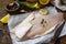 Seafood, raw white fish fillet for cooking. Fresh fillet Pangasius with spices, lemon and thyme on rustic wooden table.