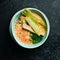 Seafood soup. Creamy tuna soup in a bowl on a black stone background. Top view. Rustic style