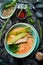 Seafood soup. Creamy tuna soup in a bowl on a black stone background. Top view. Rustic style