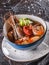 Seafood soup with langoustine, mussels, squid, fillet salmon, shrimp and celery in bowl over dark background. Healthy food, diet