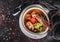 Seafood soup with langoustine, mussels, squid, fillet salmon, shrimp and celery in bowl over dark background. Healthy food, diet