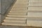 Seafront with plane trees growing out of the lattice in the pavement. a beige concrete staircase serves as a theater bench overloo