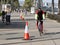 Seafront promenade with people moving along traffic cones with barricade tape