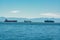 Seagoing vessels passing a harbor. Ship traffic to a port