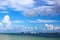 Seagull flies high in beautiful bright blue sky  above the sea with ships and boats